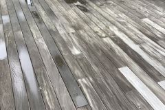 Before and after pressure washing results on a large wooden deck